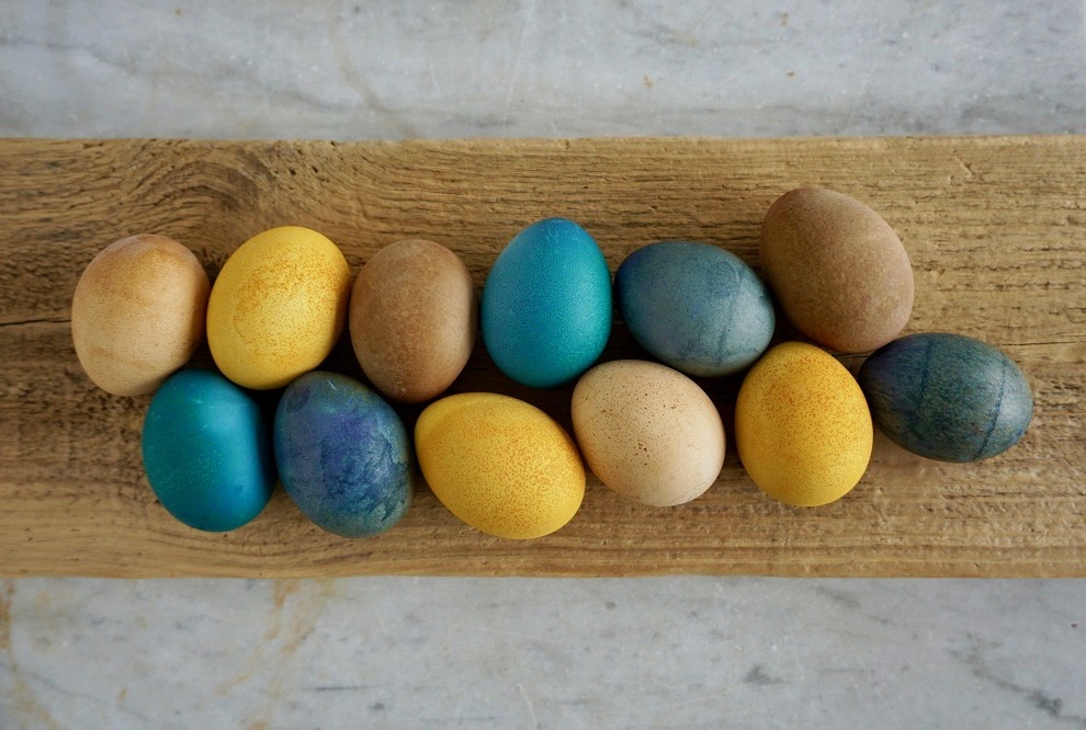 Naturfärgade ägg ligger upplagda på en bräda