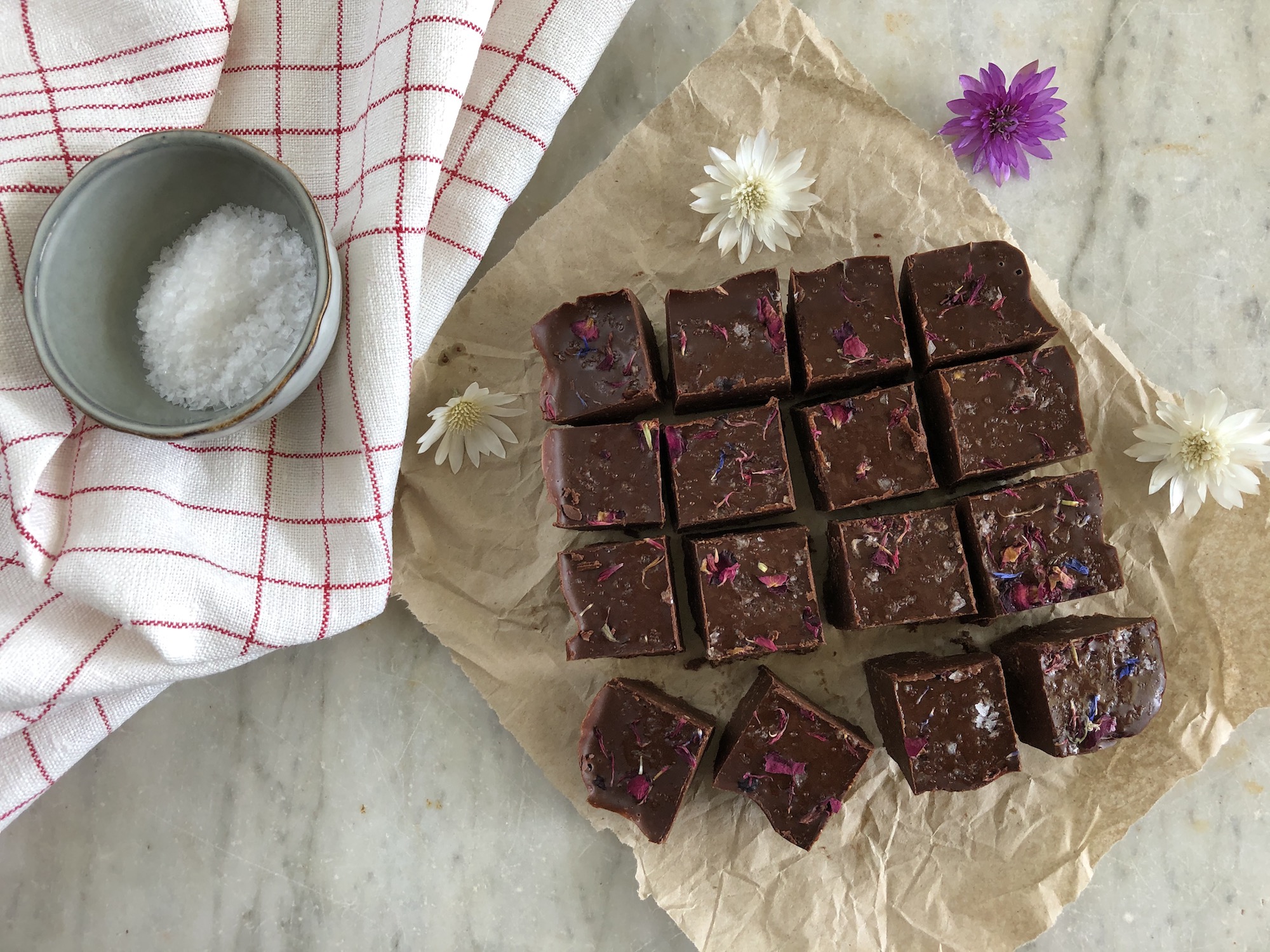 Uppskuren Kollagen fudge på bakplåtspapper med blommor som dekoration