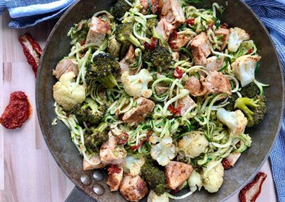 Zucchinipasta med kyckling, pesto och soltorkade tomater redo att avnjutas direkt från pannan