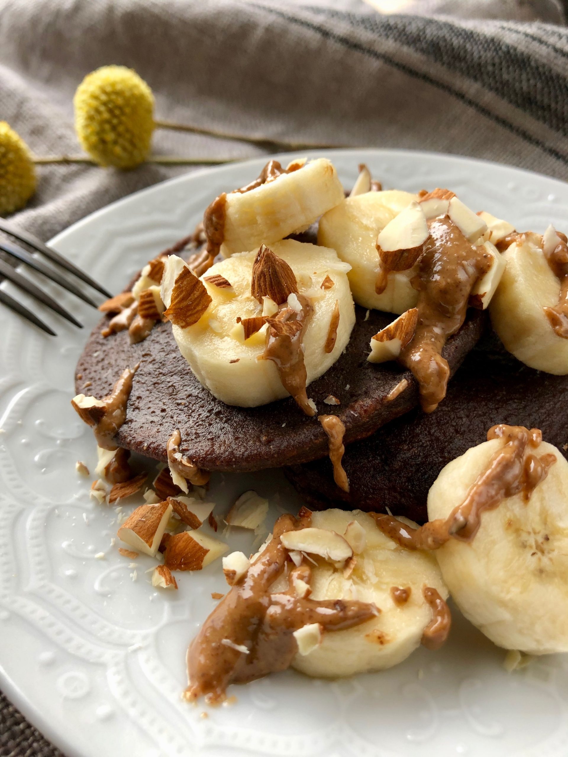 Äggfria chokladplättar på bananmjöl toppade med banan, mandelsmör och hackad mandel