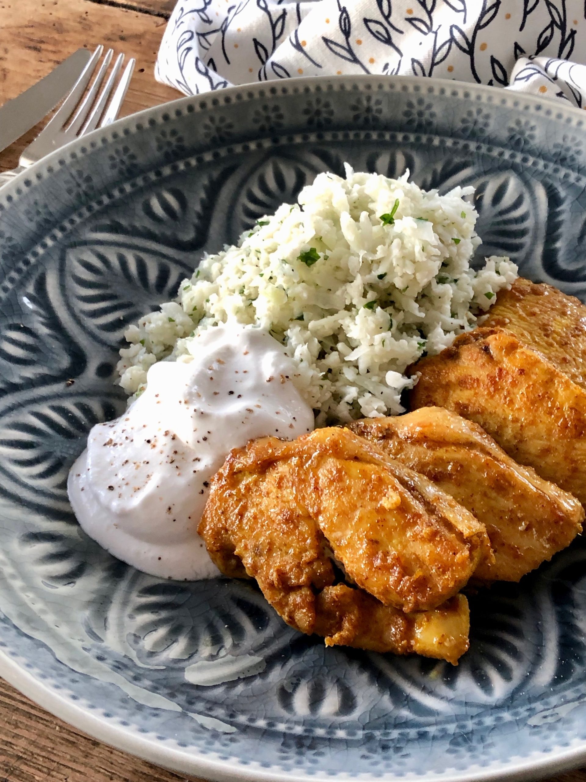 Currystekt kycklingfilé upplagt på fat tillsammans med vitlöksghurt och blomkålsris